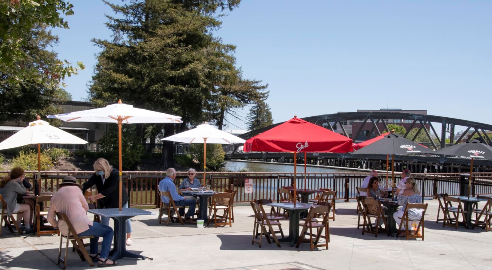 diners on restaurant patio under umbrellas on a summer day