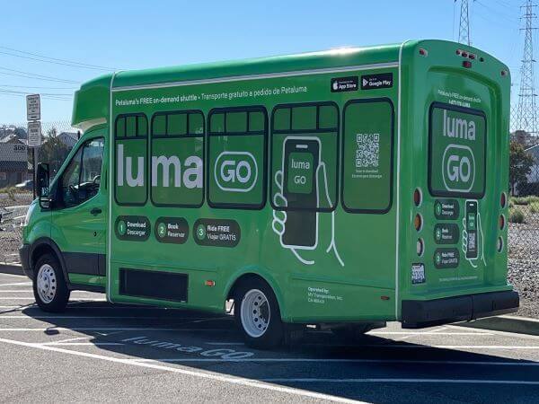 LumaGo green shuttle parked on pavement marked out with LumaGo